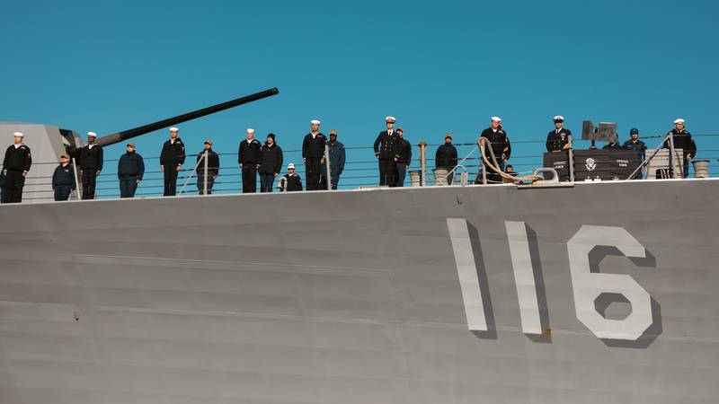 The crew of the USS Thomas Hudner waits to dock.