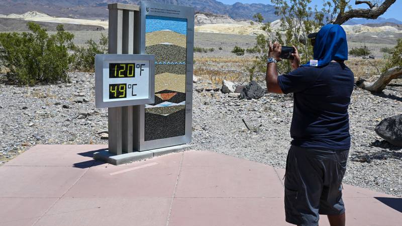 man takes photo of thermometer reading 120 degrees