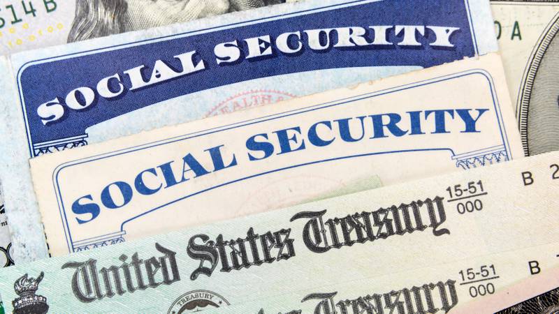 Macro view of Social Security cards, United States Treasury checks and cash.