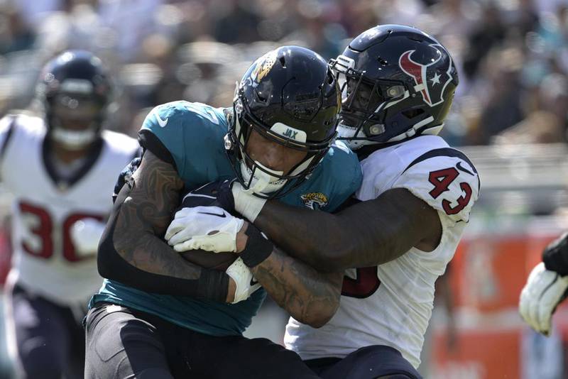 Jacksonville Jaguars tight end Evan Engram (17) is tackled by Houston Texans linebacker Neville Hewitt (43) during the second half of an NFL football game in Jacksonville, Fla., Sunday, Oct. 9, 2022. (AP Photo/Phelan M. Ebenhack)
