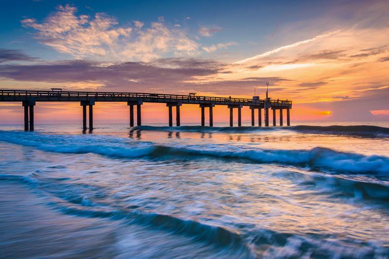 Waves on the Atlantic Ocean and fishing pier at sunrise, St. Augustine Beach, Florida.