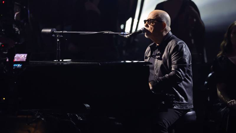 Billy Joel playing piano on stage.
