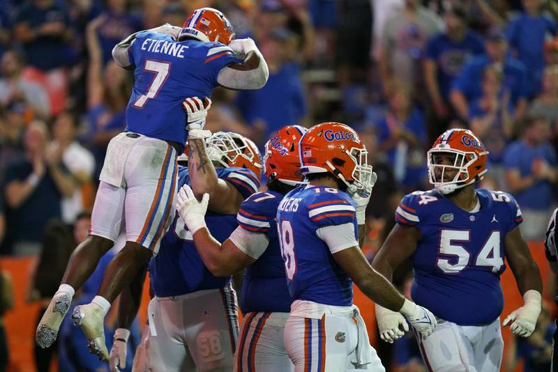 Florida offensive lineman Austin Barber hoists running back Trevor Etienne (7) who celebrates his go-ahead touchdown on a 3-yard run against South Florida during the second half of an NCAA college football game, Saturday, Sept. 17, 2022, in Gainesville, Fla.
