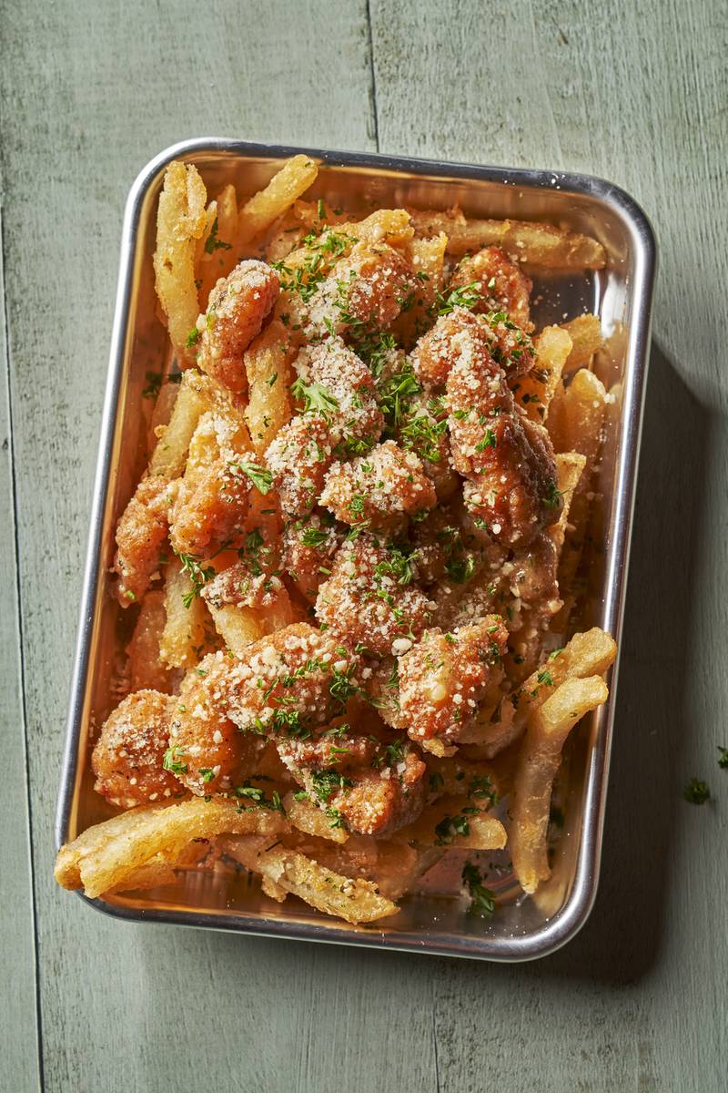 Garlic Parmesan Chicken Fries: Popcorn chicken tossed in garlic parmesan sauce, topped with parmesan cheese and parsley. Served on a bed of fries.