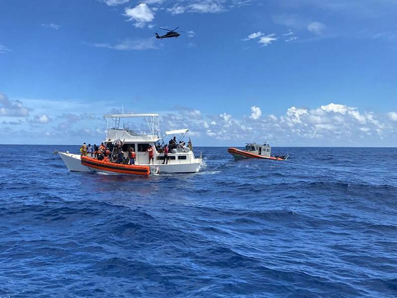 This image provided by the U.S. Coast Guard shows Coast Guard law enforcement crews aiding people from an unsafe and overloaded 40-foot cabin cruiser about 20 miles off Boca Raton, Fla., Oct. 12, 2022. The people were transferred to Bahamian authorities, Oct 16, 2022.