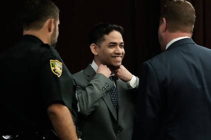 Defendant Mario Fernandez Saldana, center, smiles while fixing’s tie and collar while talking with one of his defense attorneys Jesse Dreicer, right, before the start of jury selection in Saldana’s murder trial Monday morning, August 10, 2026 in the Duval County Courthouse in Jacksonville, Fla.  Mario Fernandez Saldana is charged with first-degree murder and solicitation to commit a capital felony in the 2022 murder of his wife's ex-husband, Jared Bridegan, in Jacksonville Beach. [Doug Engle/Florida Times-Union]