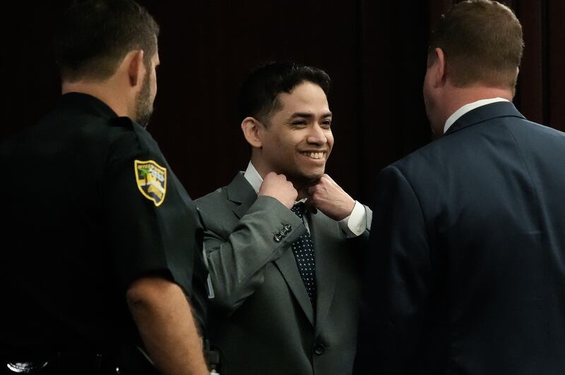 Defendant Mario Fernandez Saldana, center, smiles while fixing’s tie and collar while talking with one of his defense attorneys Jesse Dreicer, right, before the start of jury selection in Saldana’s murder trial Monday morning, August 10, 2026 in the Duval County Courthouse in Jacksonville, Fla.  Mario Fernandez Saldana is charged with first-degree murder and solicitation to commit a capital felony in the 2022 murder of his wife's ex-husband, Jared Bridegan, in Jacksonville Beach. [Doug Engle/Florida Times-Union]