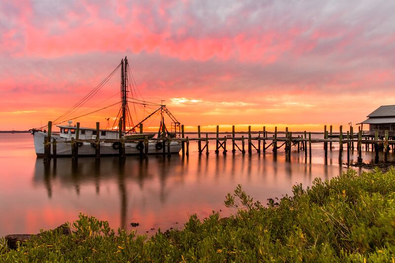 Shrimping boat docked during sunset.