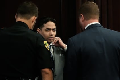 Defendant Mario Fernandez Saldana, center, fixes his tie and collar while talking with one of his defense attorneys Jesse Dreicer, right, before the start of jury selection in Saldana’s murder trial Monday morning, August 10, 2026 in the Duval County Courthouse in Jacksonville, Fla. [Doug Engle/Florida Times-Union]