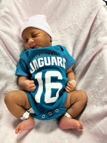 Babies from various local Baptist Health hospitals wearing Trevor Lawrence jersey onesies