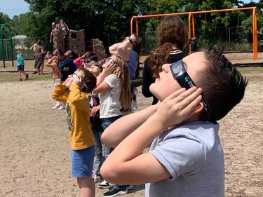 Students at Bartram Springs Elementary School take in the view of the 2024 solar eclipse.