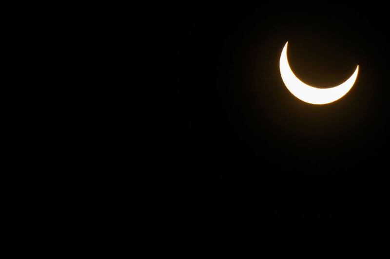 KERRVILLE, TEXAS - OCTOBER 14: The moon descends over the sun's horizon during an annular solar eclipse on October 14, 2023 in Kerrville, Texas. Differing from a total solar eclipse, the moon in an annular solar eclipse covers part of the sun's light, creating the "ring of fire" effect around the moon. (Photo by Brandon Bell/Getty Images)