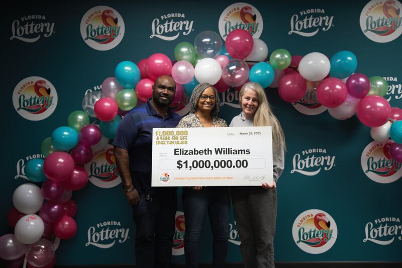 Elizabeth Williams (center) of Jacksonville poses with two other members of the Lucky Lotto Champs group and oversized check after claiming a $1 million prize from the $1,000,000 A YEAR FOR LIFE SPECTACULAR Scratch-Off game at Florida Lottery Headquarters in Tallahassee.