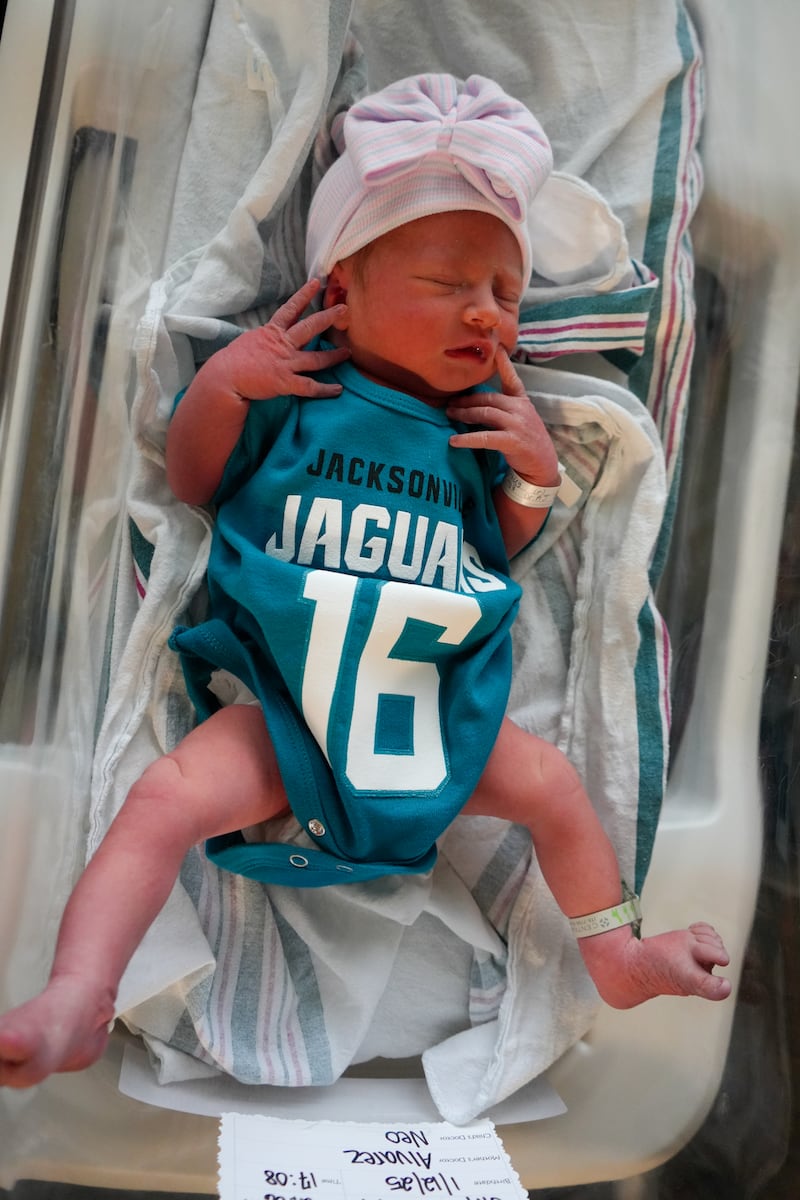 Babies from various local Baptist Health hospitals wearing Trevor Lawrence jersey onesies