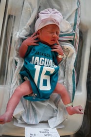 Babies from various local Baptist Health hospitals wearing Trevor Lawrence jersey onesies