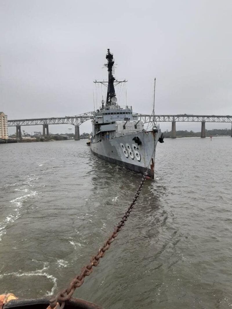 Lead Tug Elsbeth III pulls the USS Orleck. The bridge in the background is Interstate 10.