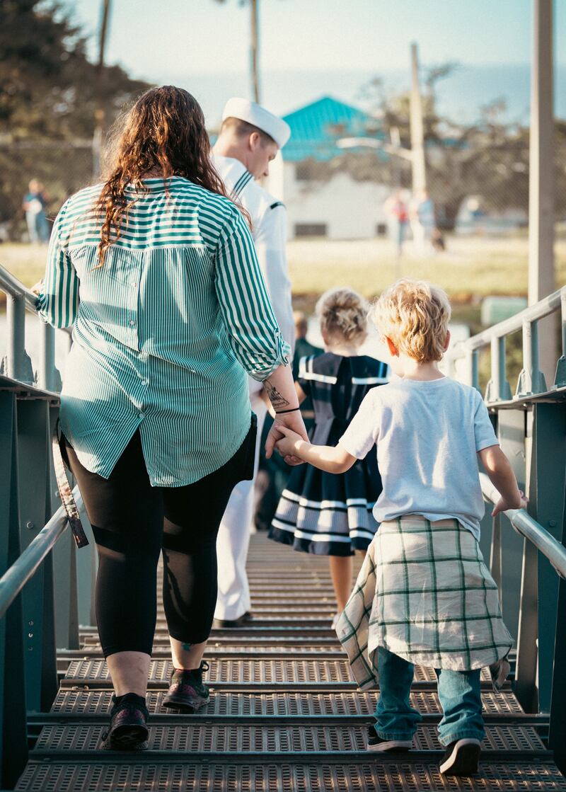 A family holds hands before their loved one gets ready to depart on board the USS Mason.