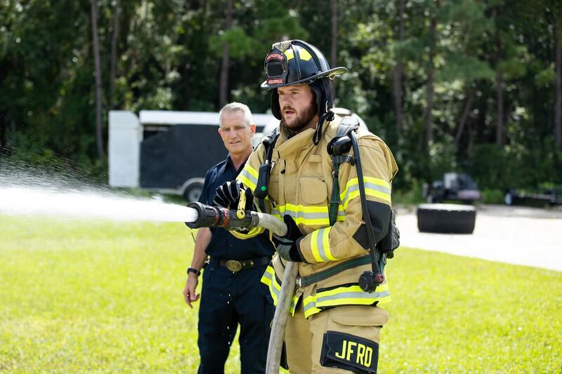 Jags' Luke Fortner gets an education on operating the fire hose.