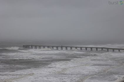 Jacksonville Beach pier in stormy waters s
