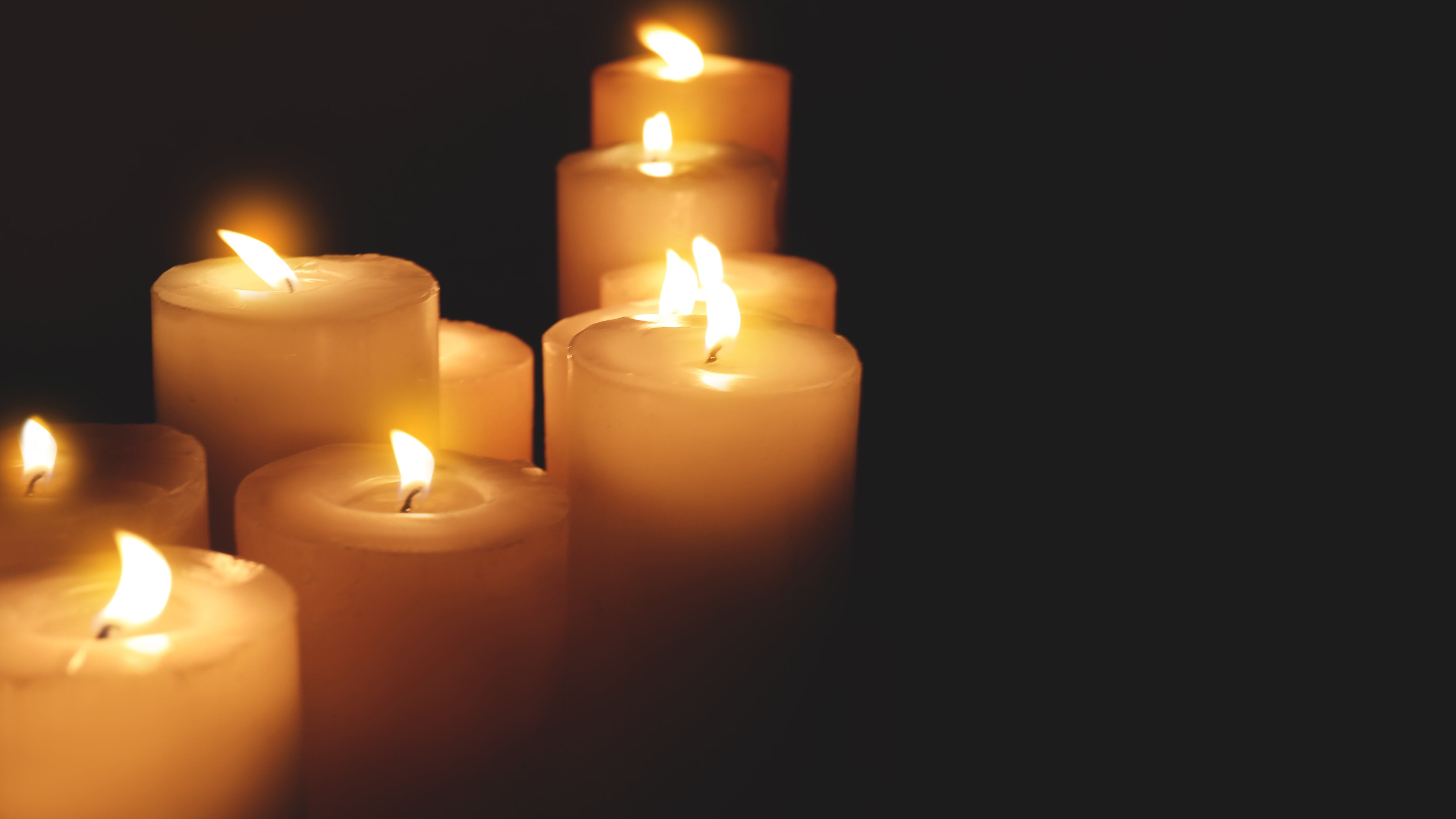 Many burning candles on dark background