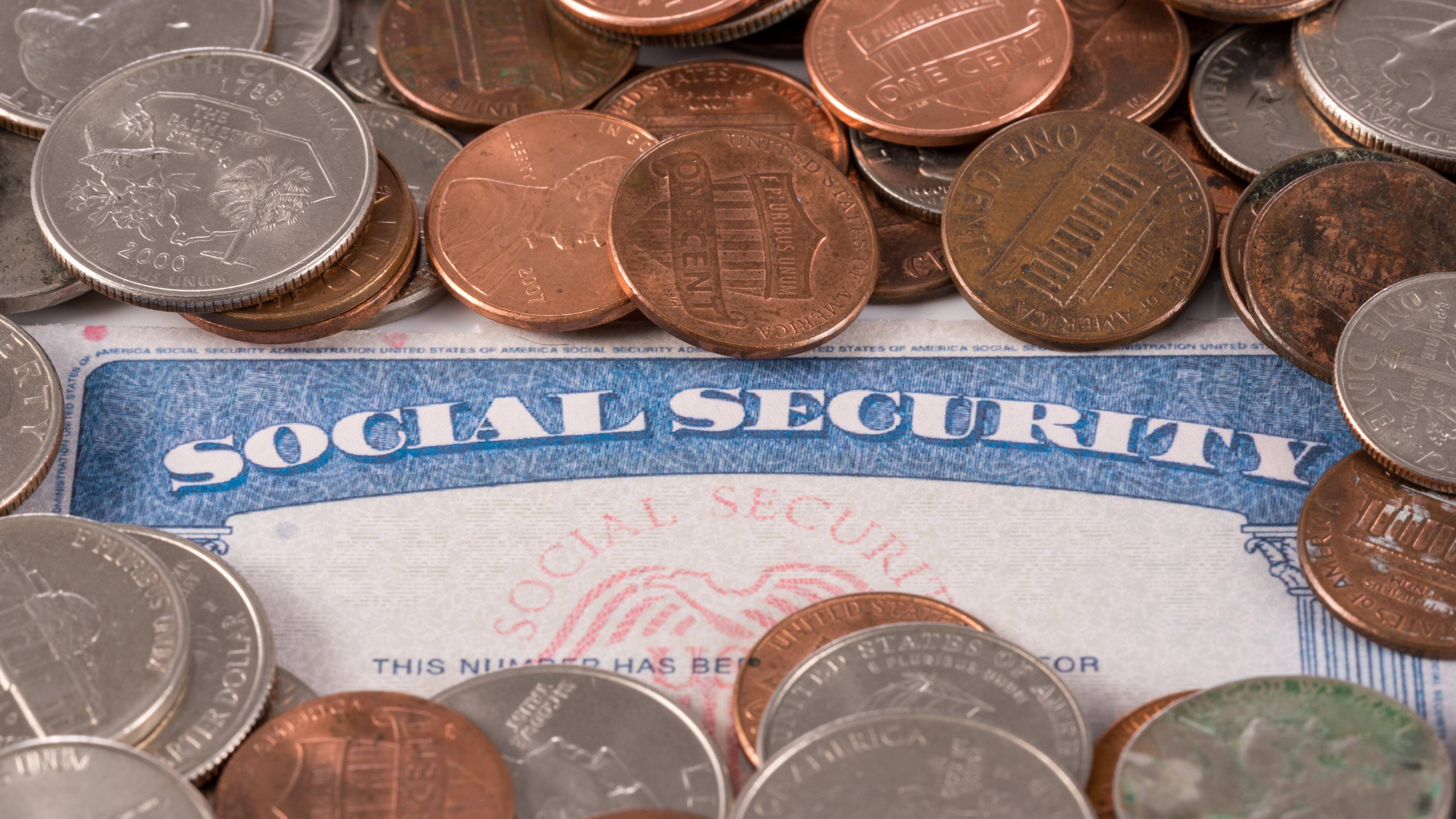 USA social security card with coins and cash to show funding crisis in the trust fund