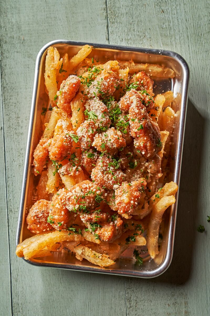 Garlic Parmesan Chicken Fries: Popcorn chicken tossed in garlic parmesan sauce, topped with parmesan cheese and parsley. Served on a bed of fries.