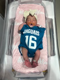 Babies from various local Baptist Health hospitals wearing Trevor Lawrence jersey onesies