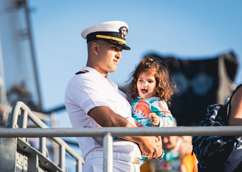 A sailor holds his daughter as families prepare for their loved ones to deploy on a regularly planned deployment into the Mediterranean Sea.