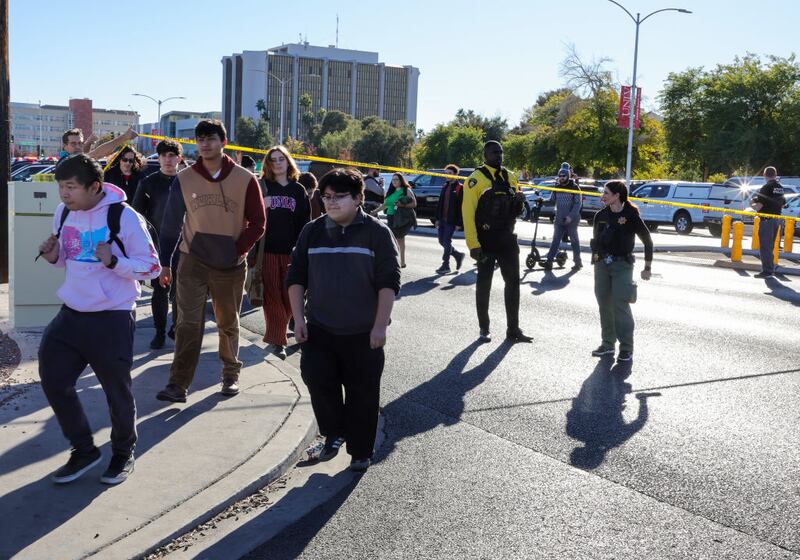 LAS VEGAS, NEVADA - DECEMBER 06: People cross Maryland Parkway as they are led off of the UNLV campus after a shooting on December 06, 2023 in Las Vegas, Nevada. According to Las Vegas Metro Police, a suspect is dead and multiple victims are reported after a shooting on the campus. (Photo by Ethan Miller/Getty Images)