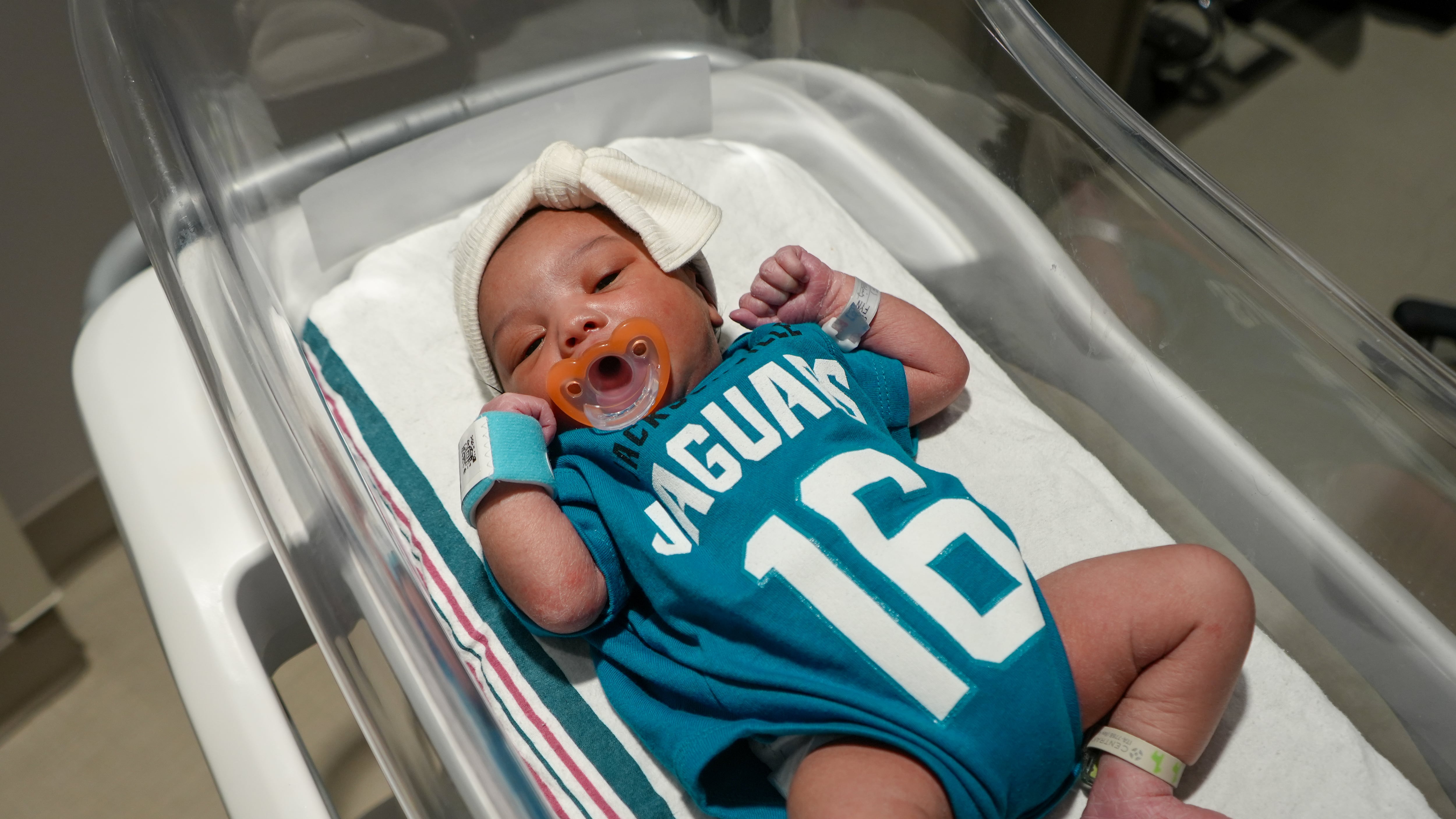 Babies from various local Baptist Health hospitals wearing Trevor Lawrence jersey onesies