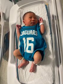 Babies from various local Baptist Health hospitals wearing Trevor Lawrence jersey onesies