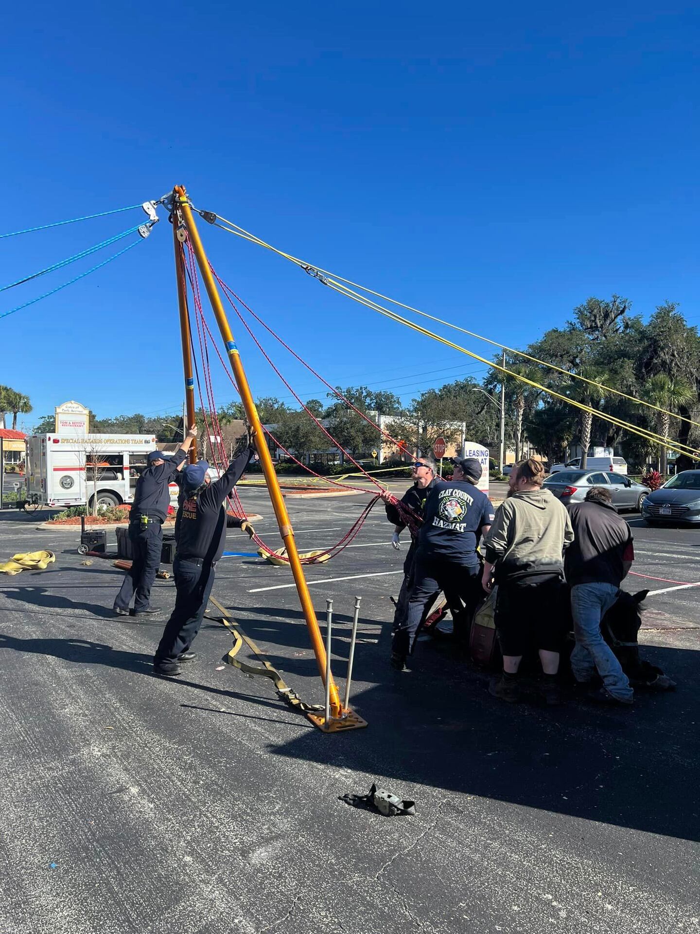 Firefighters work together to raise a hoist during a horse rescue in Orange Park on Monday.