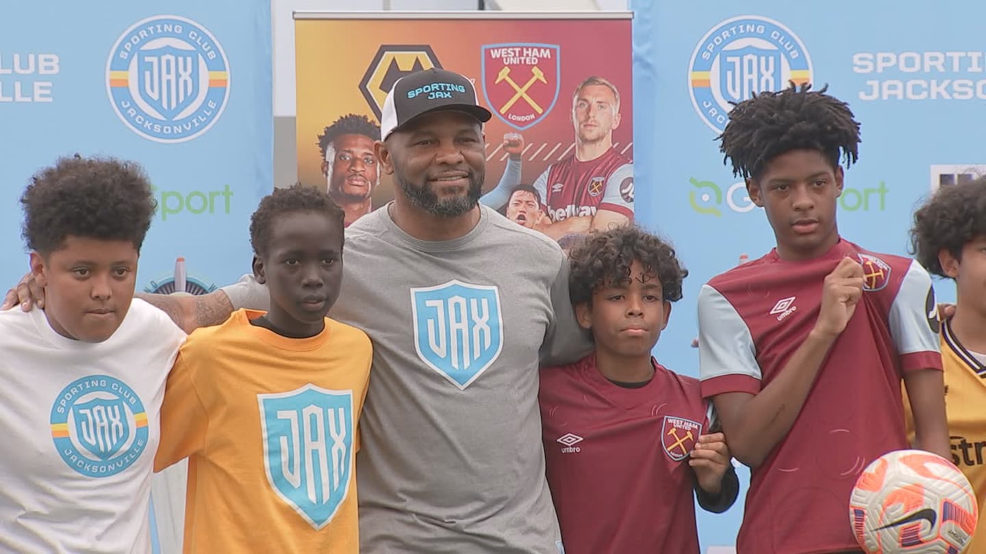 Jaguars running back legend Fred Taylor, (center) part owner of Sporting Club Jacksonville, poses with youth soccer players.