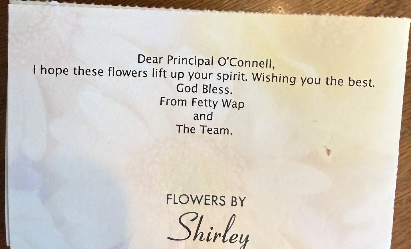 The card reads: “Dear Principal O’Connell. I hope these flowers lift up your spirit. Wishing you the best. God bless. From Fetty Wap and The Team.”