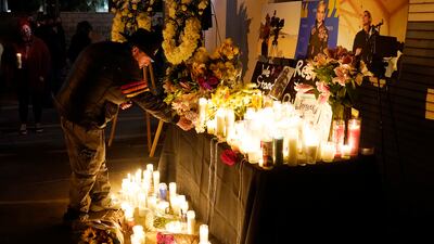 Russ Backers, a stagehand and welder in IATSE Local 33, lays down his union pin for the late cinematographer Halyna Hutchins during a candlelight vigil for her, Sunday, Oct. 24, 2021, in Burbank, Calif. A prop firearm discharged last Thursday by actor Alec Baldwin, while producing and starring in a Western movie in Santa Fe, N.M., killed Hutchins and wounded director Joel Souza.